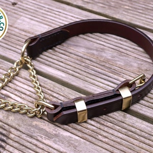 May include: A brown leather dog collar with a brass chain and buckle. The collar is made of high-quality leather and has a sturdy brass buckle.