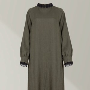 Puede incluir: Un vestido largo de lino verde oliva con cuello y puños de encaje negro.