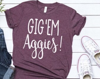 May include: A maroon t-shirt with the text "GIG'EM Aggies!" printed in white.