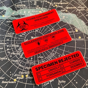 A picture of three different designs of rectangular red stickers.