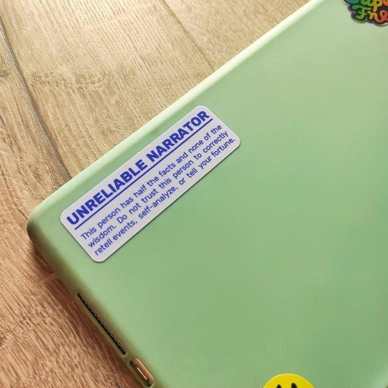 A white and blue sticker on a tablet case reading 'UNRELIABLE NARRATOR -  This person has half the facts and none of the wisdom. Do not trust this person to correctly retell events, self-analyze, or tell your fortune.'