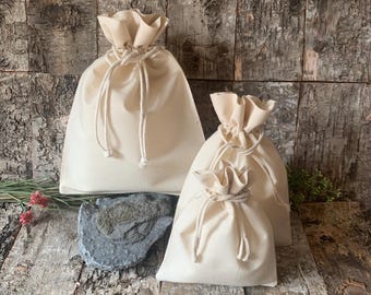 Bolsa de regalo de algodón con cordón ajustable, color crema.