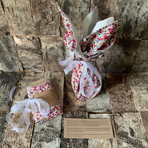 May include: A floral fabric gift bag tied with a white ribbon and a small card that says "Small Japanese Fabric Gift". The bag is on a wooden surface.