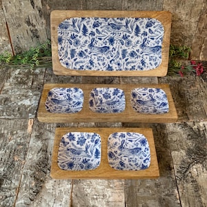 May include: A set of four wooden serving dishes with a blue and white floral pattern featuring rabbits. The dishes are ideal for serving snacks, appetisers, or dips.