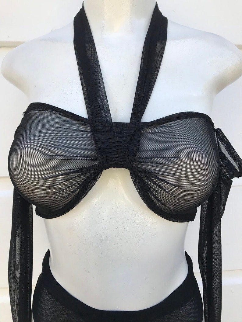 May include: Black mesh halter top with long sleeves and a gathered detail at the bust.