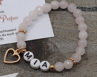A delicate bracelet made of faceted rose quartz in 4 mm, a rose gold plated metal fish, a heart and a small angel pendant.