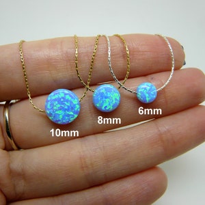 May include: Three silver necklaces with blue opal pendant stones. The stones are 6mm, 8mm, and 10mm in diameter.