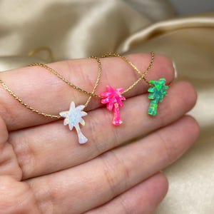 以下が含まれることがあります： オパール製のヤシの木のペンダントが付いたゴールドネックレスが3本。ヤシの木は白、ピンク、緑です。