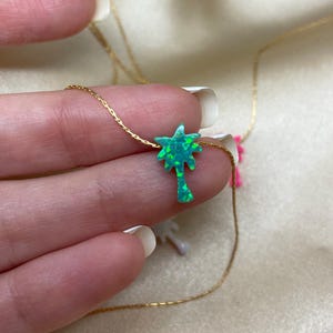以下が含まれることがあります： 緑のオパール製のヤシの木のペンダントが付いたゴールドチェーンネックレス。ペンダントは繊細で細部までこだわったデザインで、キラキラと輝いています。