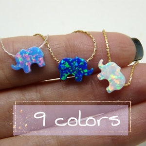 May include: Three silver and gold chains with opal elephant pendants. The elephants are in blue, green, and white opal. The text "9 colors" is on a pink background.
