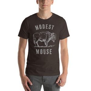 May include: A dark brown t-shirt with a gray graphic of a buffalo and the text "MODEST MOUSE" printed on the front.