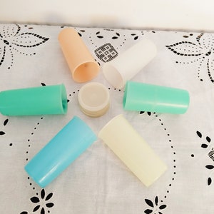 以下が含まれることがあります： 薄い青、ターコイズ、ピーチ、白、クリームなど、さまざまな色のプラスチックカップ6個。カップは、レース模様の白いテーブルクロスの上に星形に配置されています。