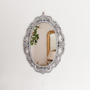 Louis XVI style patinated oval mirror