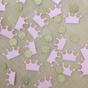 May include: Pink crown confetti with gold glitter dots on a burlap background.