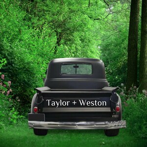 Peut inclure: Un camion vintage noir avec une inscription blanche à l'arrière indiquant "Taylor + Weston" garé dans un environnement forestier.