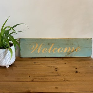Rustic Welcome Sign on light blue background - Distressed