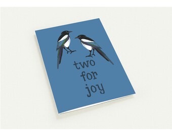 Könnte beinhalten: Blaue Grußkarte mit zwei stilisierten Elstern in Schwarz, Weiß und Türkis. Der Text "two for joy" ist in einer verspielten Schriftart darunter gedruckt. Die Karte ist innen leer.