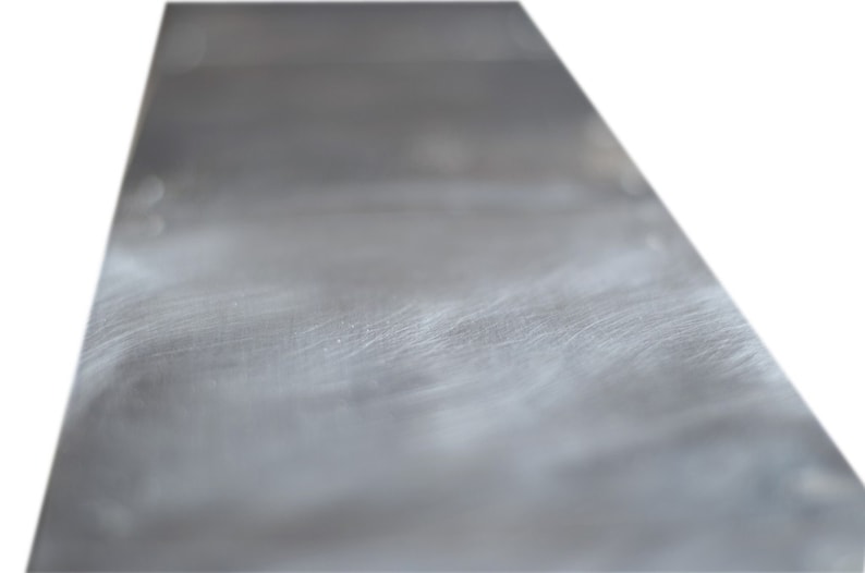 May include: A close-up of a smooth, silver metal surface with subtle scratches and a slight sheen.