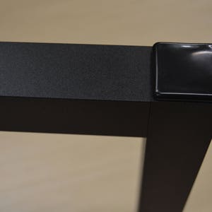 Puede incluir: Pata de mesa de metal negro con un protector de esquina de pl&aacute;stico negro.