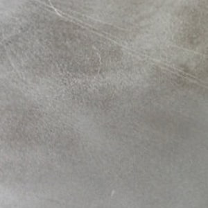 May include: A close-up of a light grey textured surface with subtle lines and a faint white spot.