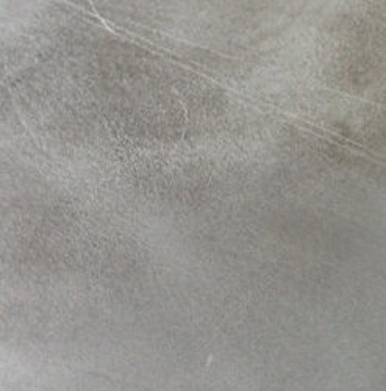 May include: A close-up of a light grey textured surface with subtle lines and a faint white spot.