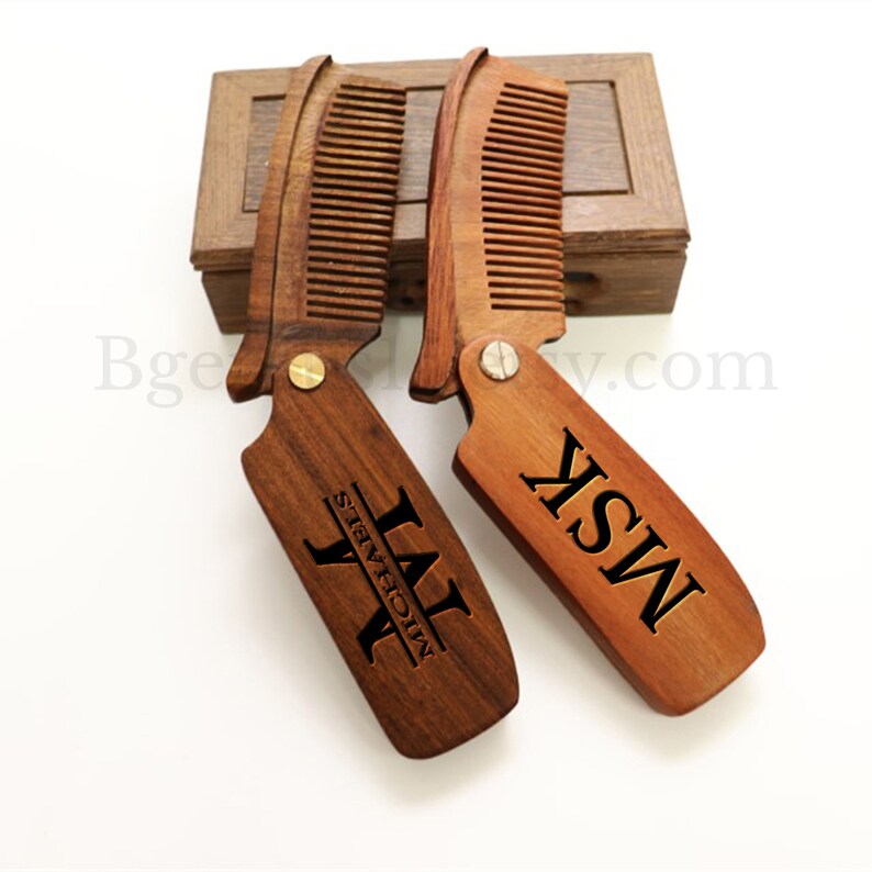 May include: Two wooden pocket combs with personalized names, "LAT" and "MISK", engraved on the handles. The combs are brown and have a natural wood finish. They are displayed in a wooden box.