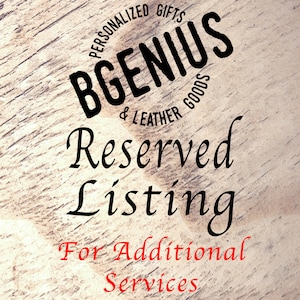 Op de afbeelding: Een houten bord met zwarte tekst die "Gepersonaliseerde Geschenken & Lederwaren" en "BGenius" in een cirkel zegt. De tekst "Gereserveerde Listing" is geschreven in een cursief schrift onder de cirkel. De tekst "Voor extra diensten" is geschreven in rood onder de cursieve tekst.