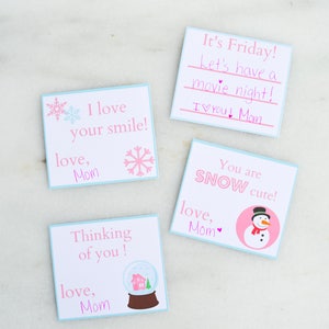 Può includere: Quattro carte rosa e blu con messaggi a tema invernale. Le carte dicono "Adoro il tuo sorriso!", "Sto pensando a te!", "È venerdì! Andiamo a vedere un film! Ti voglio bene! Mamma", e "Sei così carino!"