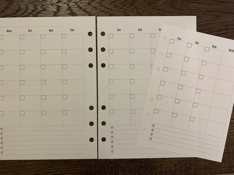 Puede incluir: Insertos de planificador blancos con un dise&ntilde;o de calendario mensual. Cada p&aacute;gina presenta una cuadr&iacute;cula para entradas diarias, con los d&iacute;as de la semana etiquetados en la parte superior. Incluye un inserto separado m&aacute;s peque&ntilde;o con un dise&ntilde;o similar.