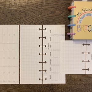 May include: A yellow planner with a rainbow and the text "the future looks BRIGHT". The planner is open to show a blank gridded page and a blank weekly calendar page.