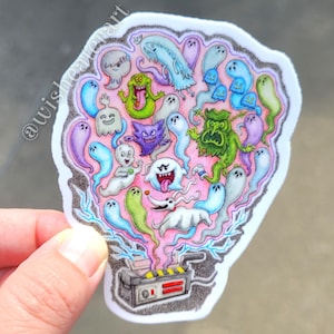 May include: A colorful sticker featuring a collection of cartoon ghosts and characters, including Slimer, Boo, and Zero. The ghosts are in various colors, including green, blue, purple, and white, with a pink background. A Ghostbusters-style device is at the bottom.
