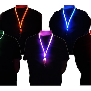 May include: A collection of glowing lanyards in various colors, including orange, blue, green, purple, and red. Each lanyard is illuminated, creating a vibrant effect against a dark background. The lanyards are worn around the neck.