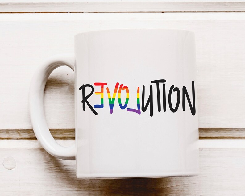 May include: White ceramic coffee mug with a rainbow-colored "REVOLUTION" graphic in black lettering.