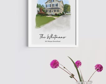 May include: A framed watercolor print of a two-story house with a green lawn and blue sky. The text "The Whitmans" and address "301 Whisper Brook Road" are below the house. A glass vase with pink flowers is in the foreground.