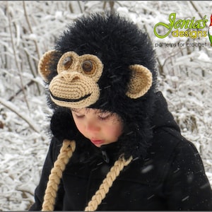 Peut inclure: Un enfant portant un bonnet de singe en crochet noir avec une bordure en fourrure brune. Le bonnet a de grands yeux en boutons bruns et un nez en crochet brun. L'enfant porte une veste noire et se tient dans la neige.