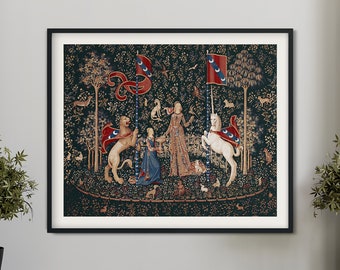 May include: Framed tapestry depicting a medieval scene with a lion, unicorn, and figures in a forest. The artwork has a dark green background with red and blue accents. The tapestry is displayed in a black frame.