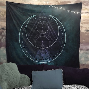 Puede incluir: Un tapiz azul oscuro con un dise&ntilde;o geom&eacute;trico que presenta una luna creciente, un tri&aacute;ngulo y un c&iacute;rculo. El dise&ntilde;o est&aacute; en tonos de azul y blanco, y hay un patr&oacute;n floral en la parte inferior.