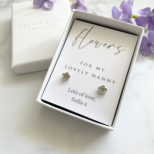 May include: A white gift box with a card that reads "flowers for my lovely nanny" and "lots of love, Sofia x". The card is decorated with two small silver flower earrings.