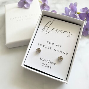 May include: A white gift box with a card that reads "flowers for my lovely nanny, lots of love, Sofia x". The card is decorated with two silver flower earrings.