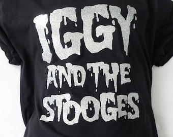 May include: Black t-shirt with a silver glitter print of "IGGY AND THE STOOGES".