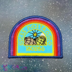 May include: Embroidered patch with a rainbow arch design. The patch features the text "USCSS NOSTROMO" in yellow, a star, and the number "180286" on a light blue background. The patch has a dark blue border.