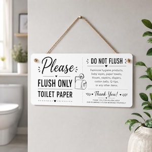 May include: A rectangular white sign with black text and graphics suspended by a jute rope. The left side reads Please FLUSH ONLY TOILET PAPER with a toilet paper roll icon. The right side reads DO NOT FLUSH followed by a list of prohibited items.