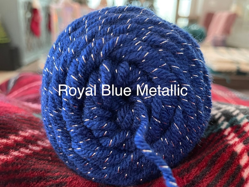 Pode incluir: Uma bola de fio azul royal com fio met&aacute;lico prateado passando por ela. O fio est&aacute; etiquetado como "Royal Blue Metallic".