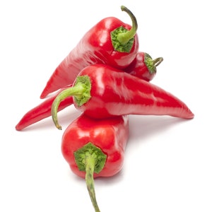May include: A close-up shot of several vibrant red chili peppers, each with a green stem. The peppers are stacked on top of each other against a clean white background. The peppers have a smooth, glossy texture.