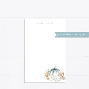 May include: Personalized notepad with the name "Beckett Pierce" printed at the top. The notepad features a watercolor illustration of a blue pumpkin with white flowers and wheat stalks.