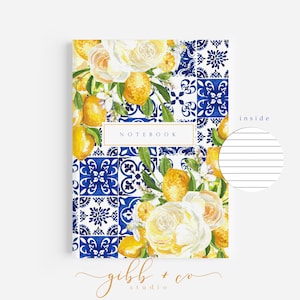 May include: A blue and white patterned notebook with a watercolor illustration of lemons, flowers, and leaves. The notebook cover says "NOTEBOOK" and has a white lined page inside.