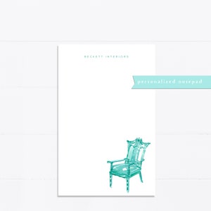 May include: A white notepad with the text "Beckett Interiors" and "personalized notepad" in teal blue. A teal blue watercolor illustration of a chair is in the bottom right corner.