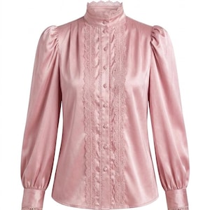 Op de afbeelding: Een lichtroze satijnen blouse met een hoge, gerimpelde kraag en lange mouwen. De voorkant heeft een verticaal kanten paneel met knopen. De mouwen hebben een lichte pof bij de schouders en kanten details bij de manchetten. Een klassieke, elegante top.