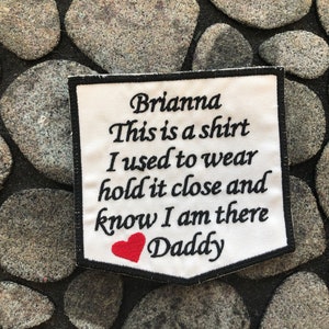May include: White fabric patch with black embroidered text that reads "Brianna This is a shirt I used to wear hold it close and know I am there Daddy" with a red embroidered heart.
