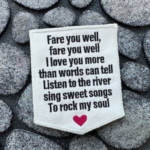 May include: White fabric patch with black text that reads "Fare you well, fare you well I love you more than words can tell Listen to the river sing sweet songs To rock my soul". A small red heart is at the bottom of the patch.